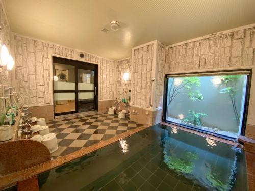 a bathroom with an aquarium in the middle of a room at Hotel Route-Inn Hon Hachinohe Ekimae in Hachinohe