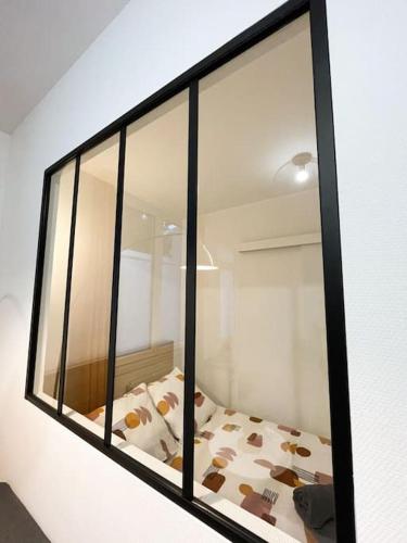 un reflet d'un lit dans une fenêtre en verre dans l'établissement Le terra apaisant - 5 min de la gare, à Tours