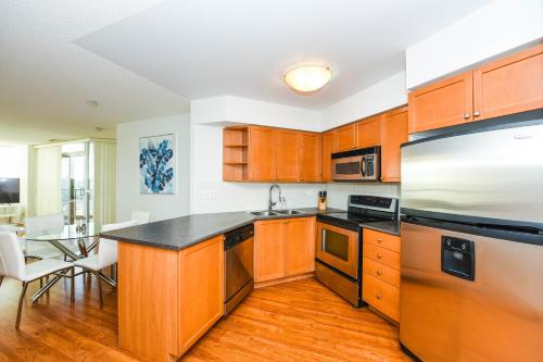 a kitchen with wooden cabinets and a black counter top at PlanURstay in Mississauga