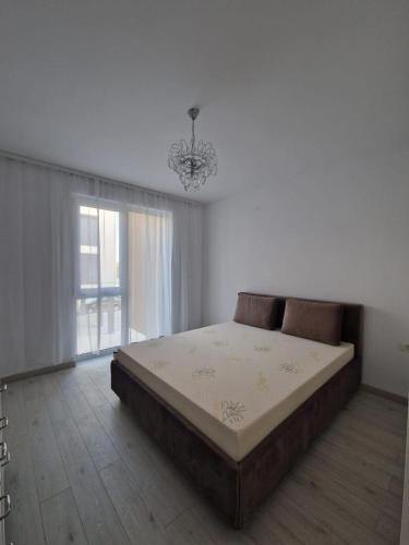 a bedroom with a bed and a chandelier at RANEVO Apartment Timis in Moşniţa Nouă