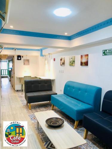 a living room with two blue couches and a table at Hotel Café Color in Armenia