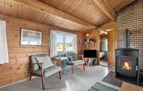 a living room with a fireplace and a table and chairs at Holiday Home Søndermarken Fanø I in Sønderho