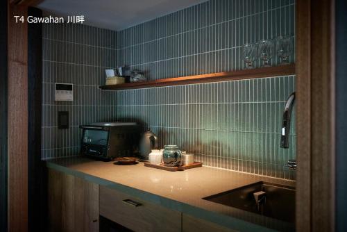 a kitchen with a sink and a microwave at 滔々 倉敷民藝館南の宿 toutou, Mingeikan Minami no Yado in Kurashiki