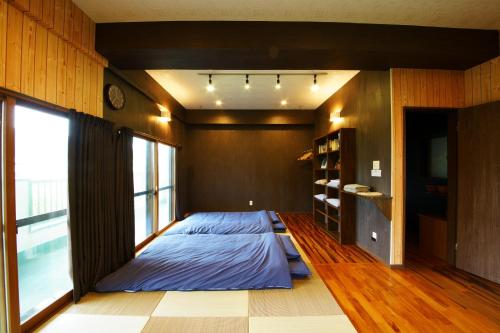 a bedroom with a bed and a large window at 奄美ゲストハウス矢之脇町-Amami Guesthouse Yanowakicho- in Amami