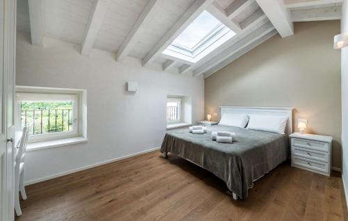 a bedroom with a bed and two windows at Nice Home In Costermano Sul Garda in Costermano sul Garda