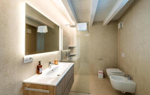 a bathroom with a sink and a toilet and a mirror at Nice Home In Costermano Sul Garda in Costermano sul Garda