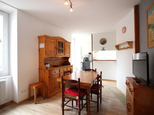 une cuisine avec une table en bois et une salle à manger dans l'établissement Appartement F2 au 1er étage avec wifi, proche centre et thermes, classé 2 étoiles, 4 couchages max - FR-1-415-46, à Le Mont-Dore