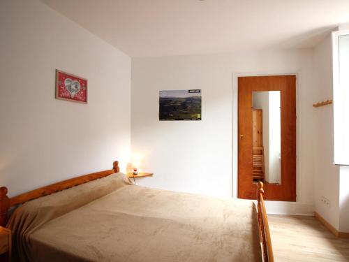 une chambre blanche avec un lit et un miroir dans l'établissement Appartement F2 au 1er étage avec wifi, proche centre et thermes, classé 2 étoiles, 4 couchages max - FR-1-415-46, à Le Mont-Dore