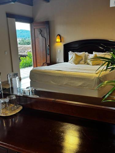 a bedroom with a bed and a table and a window at Parador Margarita in San Cristóbal de Las Casas