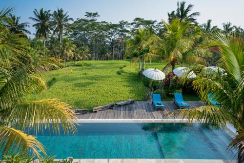 un complejo con piscina y palmeras en Ubud Sari Health Resort, en Ubud