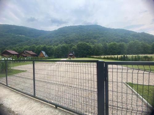 a fence in front of a field with a mountain at Holiday Home UnaPark in Krakovo