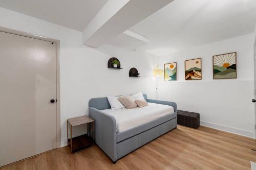 a white bedroom with a bed and paintings on the wall at New Bensenville Home by O'Hare Airport with Indoor Pool, Sauna, and Arcade in Bensenville