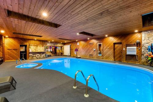 a large swimming pool in a building with a wooden ceiling at New Bensenville Home by O'Hare Airport with Indoor Pool, Sauna, and Arcade in Bensenville