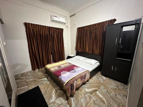 a small bedroom with a bed and a dresser at ZAHIR RESIDENCY in Kondotti