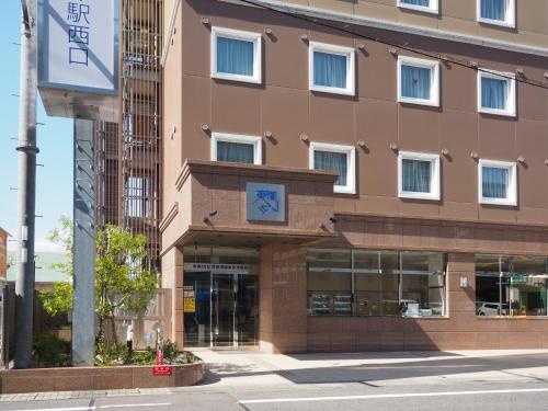 a building with a clock on the front of it at Toyoko Inn Biwako sen Minami Kusatsu eki Nishi guchi in Kusatsu
