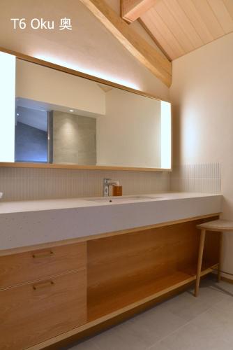 a bathroom with a sink and a mirror at 滔々 倉敷民藝館南の宿 toutou, Mingeikan Minami no Yado in Kurashiki