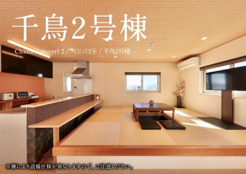 a living room with a table and a kitchen at Crystal Besso Shirahama in Shirahama
