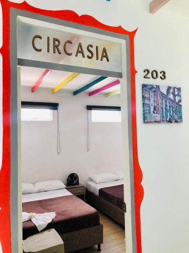 a room with two beds and a sign that says circus at Hotel Café Color in Armenia