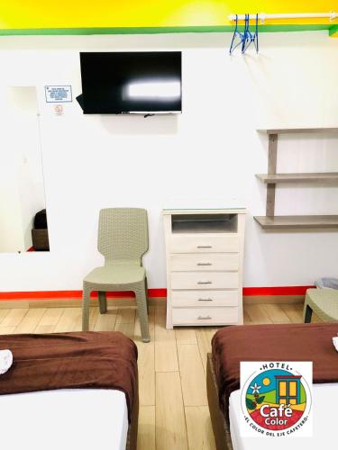 a room with two beds and a chair and a dresser at Hotel Café Color in Armenia