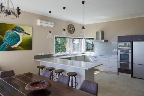 a kitchen with a bird painting on the wall at Pohutukawa Point Estate Homestead in Karaka