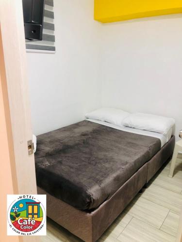 a bed sitting in a room next to a wall at Hotel Café Color in Armenia