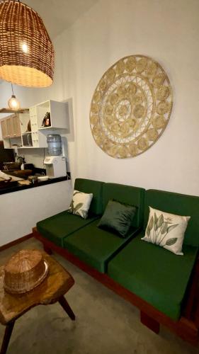 a living room with a green couch and a table at Cel de Atins Chalé - Lençóis in Atins