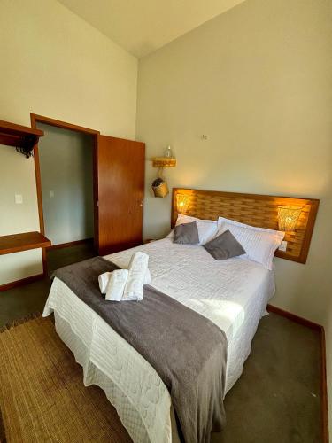 a bedroom with a large bed with two towels on it at Cel de Atins Chalé - Lençóis in Atins