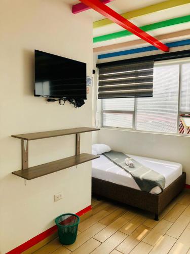 a bedroom with a bed and a flat screen tv at Hotel Café Color in Armenia