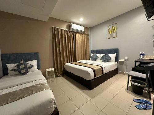a hotel room with two beds and a desk at SS Grey Hotel 2 in Kuala Lumpur