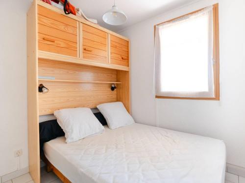une petite chambre avec un lit et une fenêtre dans l'établissement Appartement cosy 2P à Gruissan - 1 min de la plage, idéal pour 4 personnes - FR-1-409A-31, à Gruissan