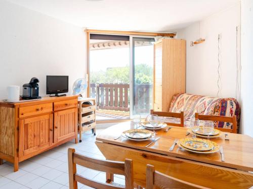 une salle à manger avec une table et une télévision dans l'établissement Appartement cosy 2P à Gruissan - 1 min de la plage, idéal pour 4 personnes - FR-1-409A-31, à Gruissan