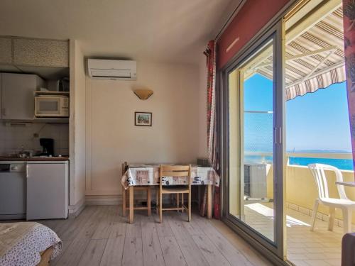 - une cuisine avec une table et une vue sur l'océan dans l'établissement Le Lavandou, studio cabine 4 pers, plage à 10m, clim, parking - FR-1-803-24, au Lavandou