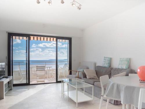 un salon avec un canapé et une table dans l'établissement Location T3 pour 4 au Lavandou, face mer, terrasse, ascenseur - FR-1-803-40, au Lavandou