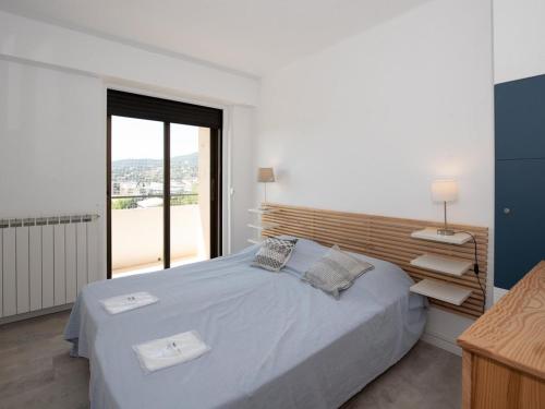 une chambre avec un grand lit et une grande fenêtre dans l'établissement Location T3 pour 4 au Lavandou, face mer, terrasse, ascenseur - FR-1-803-40, au Lavandou