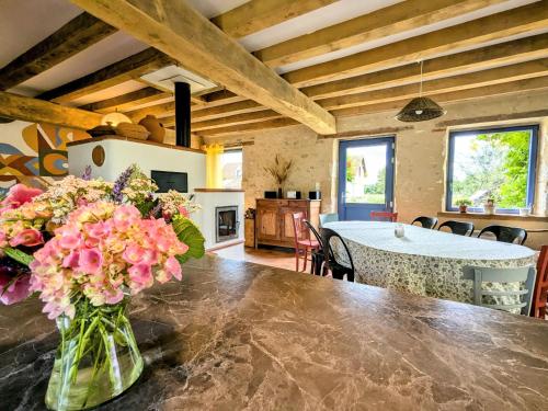 a vase of flowers on a table in a kitchen at Maison typique en Berry avec jardin privatif, BBQ et parking - FR-1-591-598 in Thenay