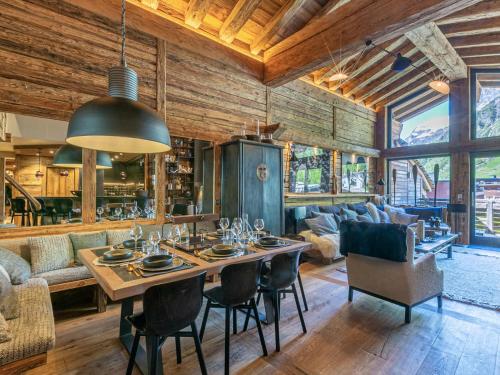 une salle à manger avec une table et des chaises dans l'établissement Luxueux Duplex 6P avec Jacuzzi, Hammam, Cheminée, Garage, Proche Pistes et Commerces - FR-1-694-357, à Val dʼIsère