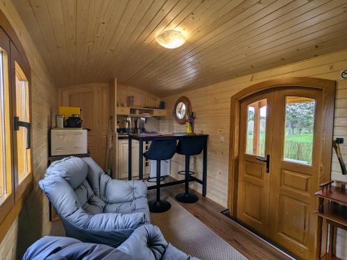 - un salon avec un canapé dans une petite maison dans l'établissement Roulotte cosy avec jacuzzi et spa, massages bien-être, nature et calme, près de Lyon - FR-1-582-477, à Monistrol-sur-Loire