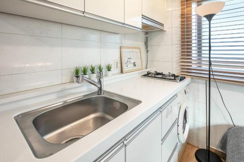 a kitchen with a stainless steel sink and a window at Studio41 in Seoul