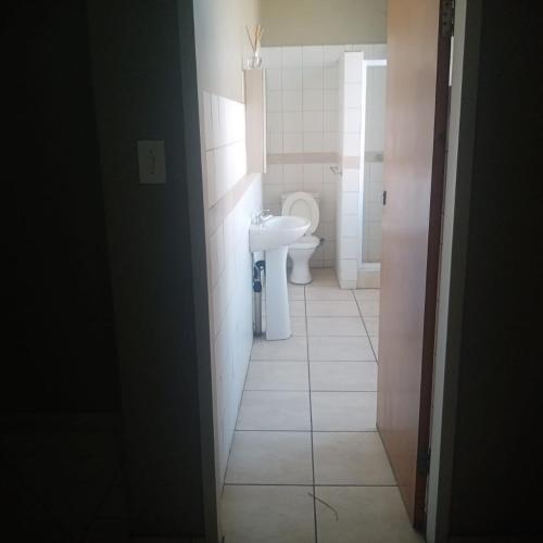 a bathroom with a toilet and a sink at Ebony Guest House in Pretoria