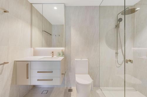 a bathroom with a shower and a toilet and a sink at Miles at Kirra Point 303 in Gold Coast