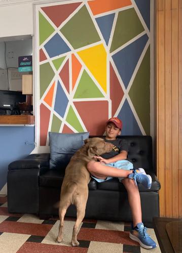 a boy sitting on a couch with a large dog at Hostal El Naufrago 2 in Manta