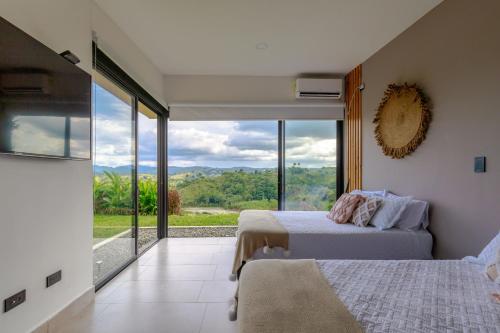 a bedroom with two beds and a large window at Casa Río Quindío in La Tebaida