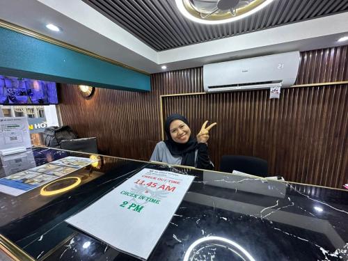 a woman standing behind a counter in a restaurant at SS Grey Hotel 2 in Kuala Lumpur