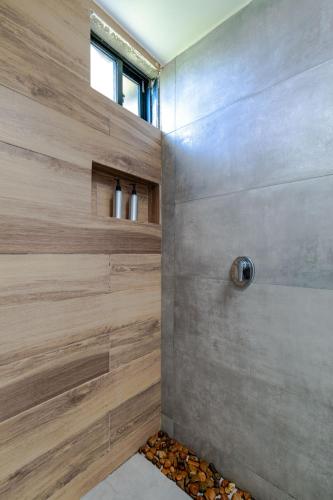 a shower in a bathroom with wooden wall at Casa Río Quindío in La Tebaida