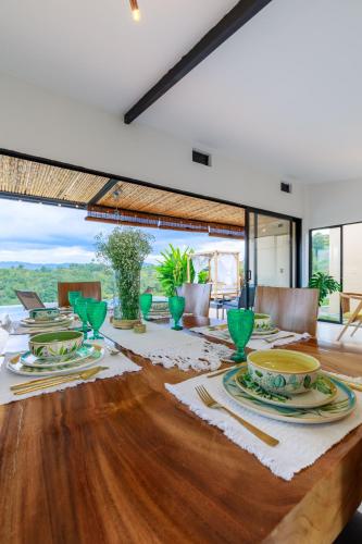 a dining room with a wooden table with plates on it at Casa Río Quindío in La Tebaida