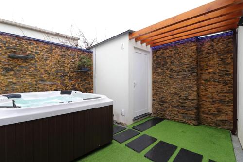 a bathroom with a bath tub and a brick wall at Dainty House in Ovar