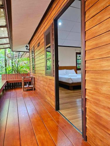 a room with a large glass door leading to a bedroom at Samran Resort in Chalong