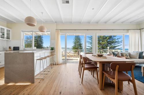 a kitchen and living room with a table and chairs at Kaya in Collaroy