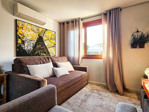 a living room with a couch and a window at Solar da Encosta 305 - Espaço e conforto no Centro in Gramado