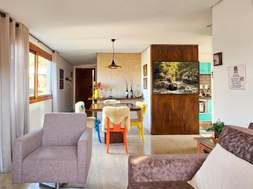 a living room with a table and chairs at Solar da Encosta 305 - Espaço e conforto no Centro in Gramado